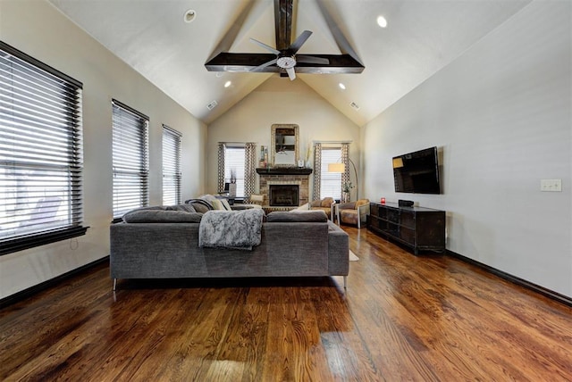 living room with ceiling fan, high vaulted ceiling, wood finished floors, a brick fireplace, and beam ceiling