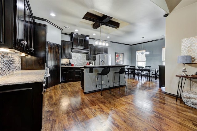 kitchen with dark wood-style floors, a breakfast bar, a kitchen island, and stainless steel fridge with ice dispenser