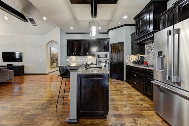 kitchen with a breakfast bar area, visible vents, appliances with stainless steel finishes, open floor plan, and a sink