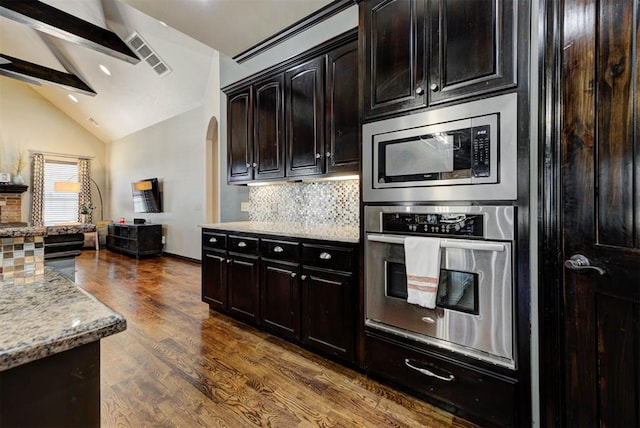 kitchen with visible vents, decorative backsplash, light stone counters, appliances with stainless steel finishes, and dark wood-style flooring