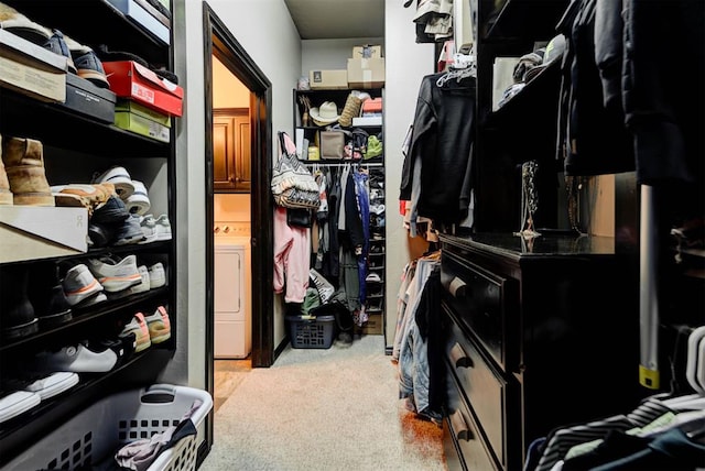 spacious closet featuring washer / clothes dryer and carpet flooring