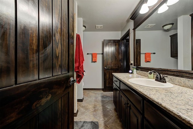 bathroom with tile patterned flooring, visible vents, vanity, and baseboards