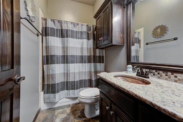 bathroom with tasteful backsplash, toilet, stone finish flooring, shower / bath combo with shower curtain, and vanity