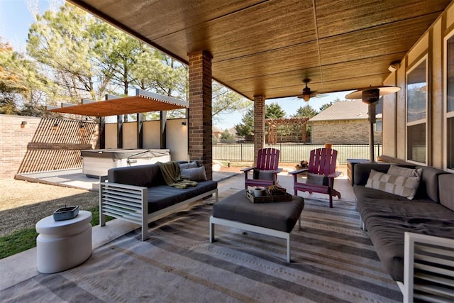 view of patio with an outdoor hangout area, ceiling fan, fence, and a hot tub