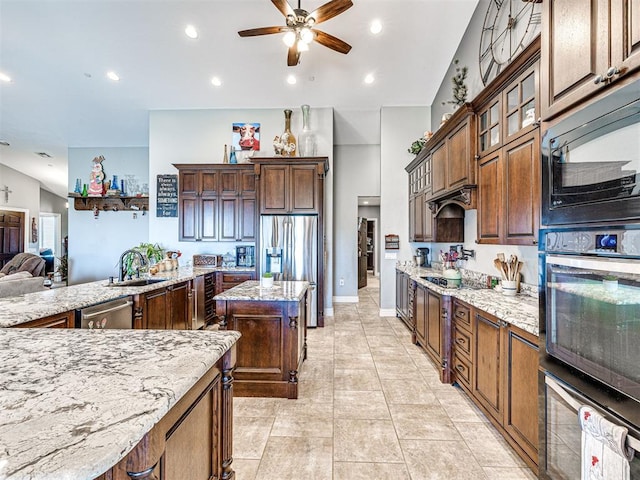 344750 E 830th Rd, Chandler, OK 74834 - kitchen with black appliances, a sink, ceiling fan, light stone counters, and a kitchen island