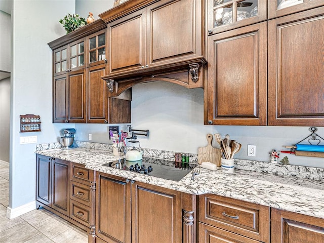 344750 E 830th Rd, Chandler, OK 74834 - kitchen with black electric cooktop, light stone counters, light tile patterned floors, and baseboards