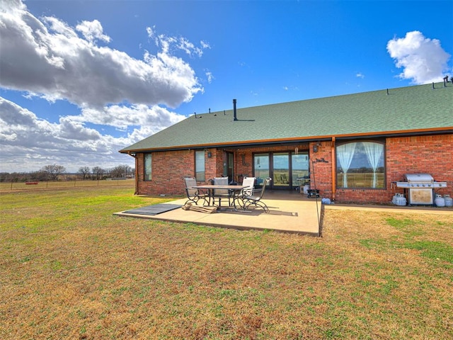 344750 E 830th Rd, Chandler, OK 74834 - back of house with brick siding, a patio, a yard, and roof with shingles
