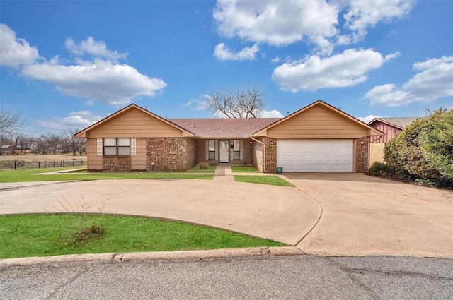 single story home with a garage, brick siding, fence, concrete driveway, and a front yard