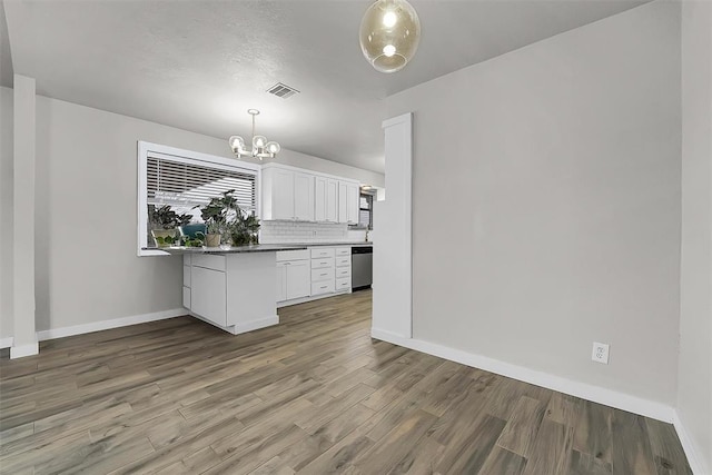 kitchen with visible vents, decorative backsplash, stainless steel dishwasher, white cabinets, and wood finished floors