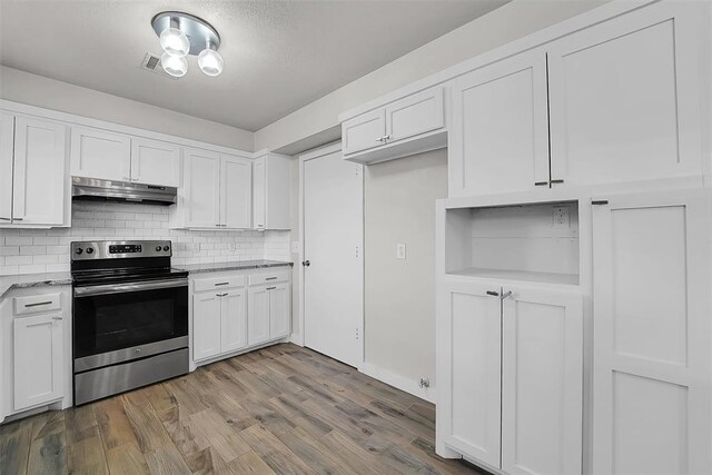 kitchen featuring wood finished floors, light stone countertops, stainless steel range with electric cooktop, under cabinet range hood, and white cabinetry