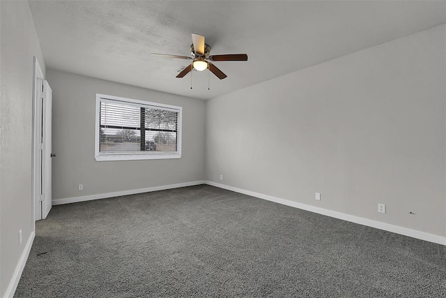 spare room featuring a textured ceiling, dark carpet, a ceiling fan, and baseboards