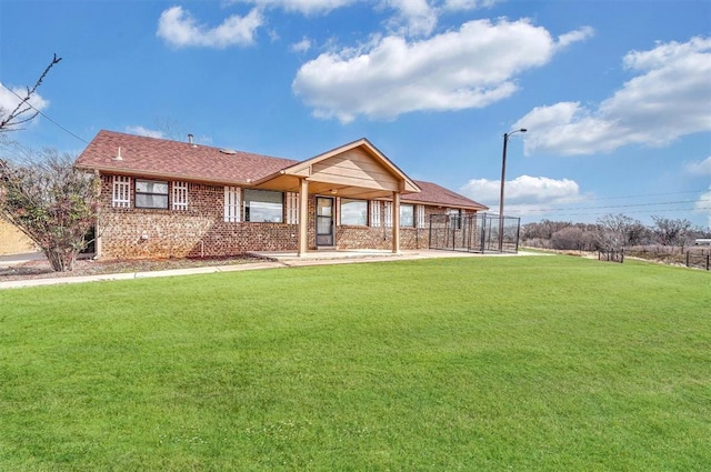 view of front of property with roof with shingles, a front lawn, and brick siding