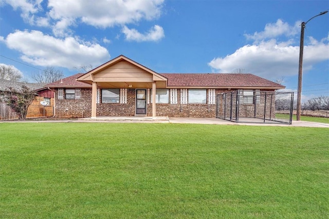 view of front of property featuring a shingled roof, brick siding, and a front lawn