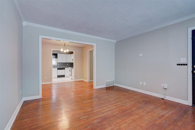 unfurnished room with light wood-type flooring, baseboards, visible vents, and ornamental molding