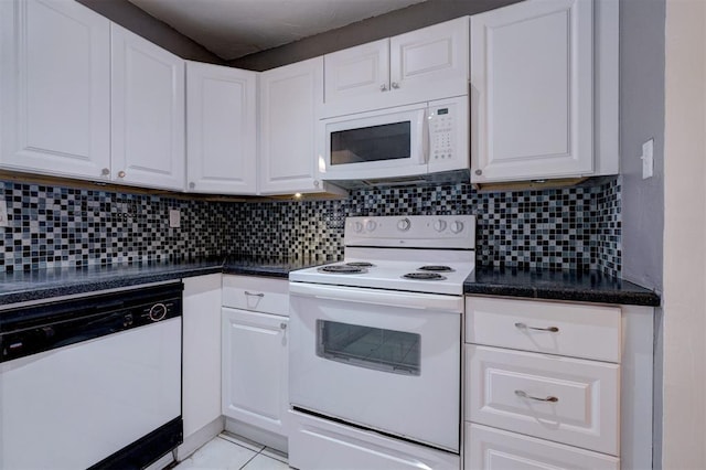 kitchen featuring white appliances, dark countertops, white cabinets, and tasteful backsplash