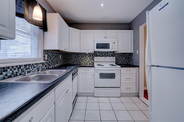 kitchen featuring white appliances, white cabinetry, a sink, and light tile patterned flooring