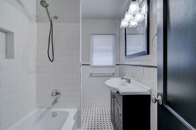 full bath featuring a wainscoted wall, tile walls, vanity, and shower / bathtub combination