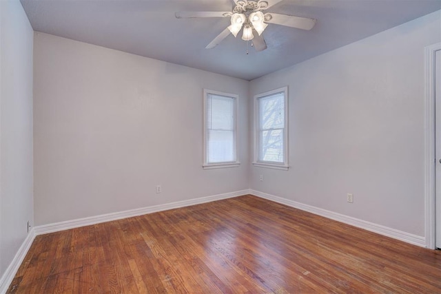 unfurnished room with wood finished floors, a ceiling fan, and baseboards