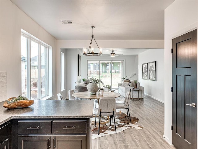 dining room featuring visible vents, a notable chandelier, light wood-style flooring, and baseboards