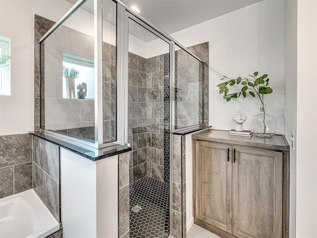 full bathroom featuring a garden tub and a shower stall