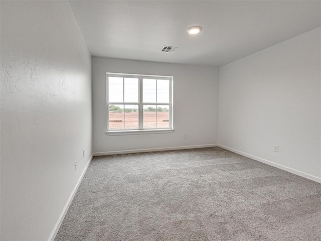 unfurnished room featuring carpet, visible vents, and baseboards