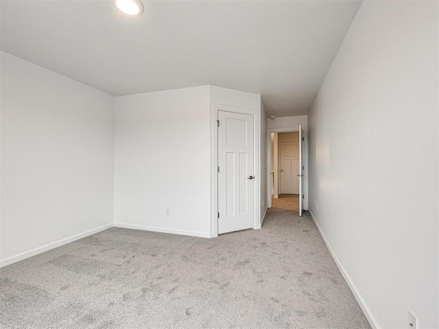 carpeted empty room with baseboards