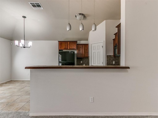 kitchen featuring black appliances, visible vents, pendant lighting, and backsplash