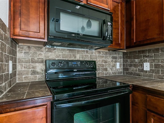 kitchen with black appliances, tasteful backsplash, and dark countertops