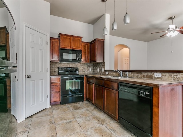 kitchen with decorative light fixtures, decorative backsplash, a sink, a peninsula, and black appliances