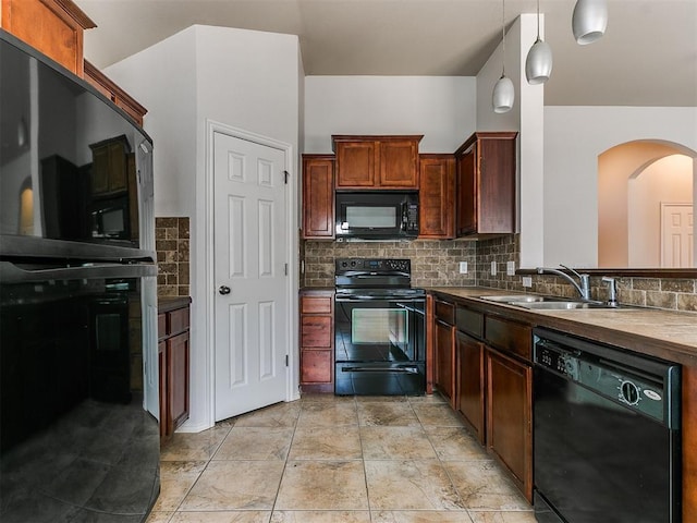 kitchen featuring dark countertops, decorative light fixtures, a sink, black appliances, and backsplash