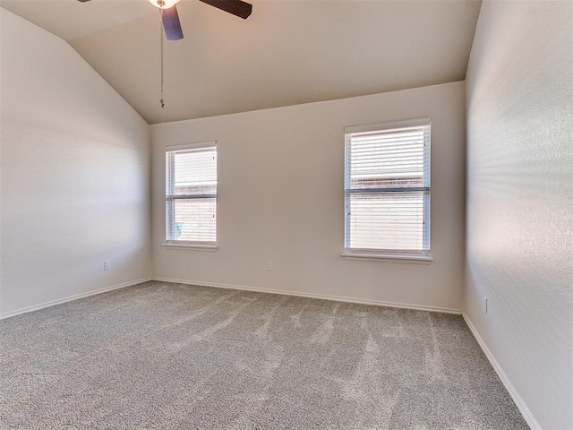 empty room with vaulted ceiling, carpet flooring, a ceiling fan, and baseboards