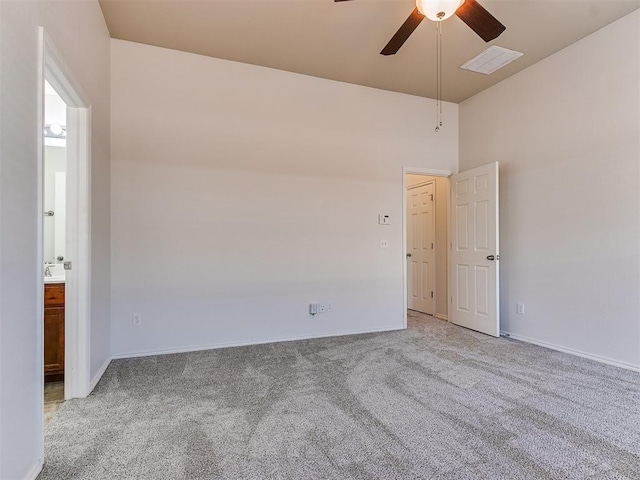 carpeted empty room with baseboards, visible vents, and a ceiling fan