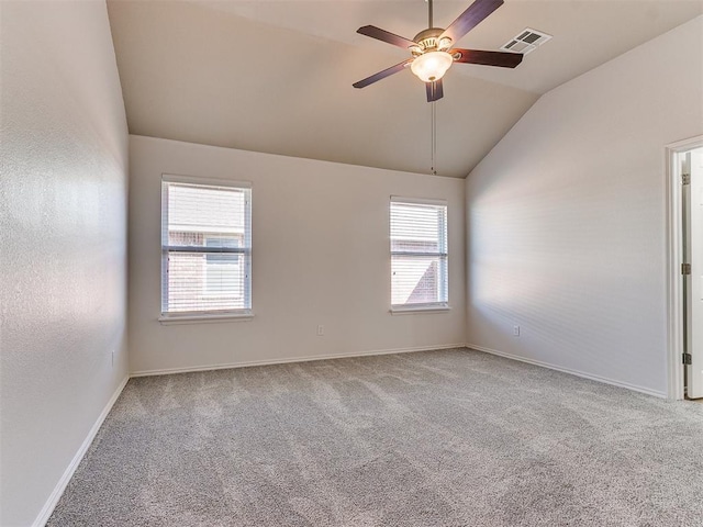 empty room with visible vents, baseboards, ceiling fan, vaulted ceiling, and carpet floors