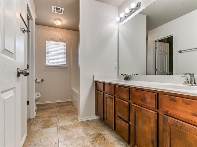 bathroom with toilet, double vanity, visible vents, and a sink