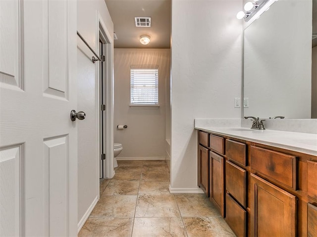 bathroom with a tub to relax in, visible vents, toilet, vanity, and baseboards