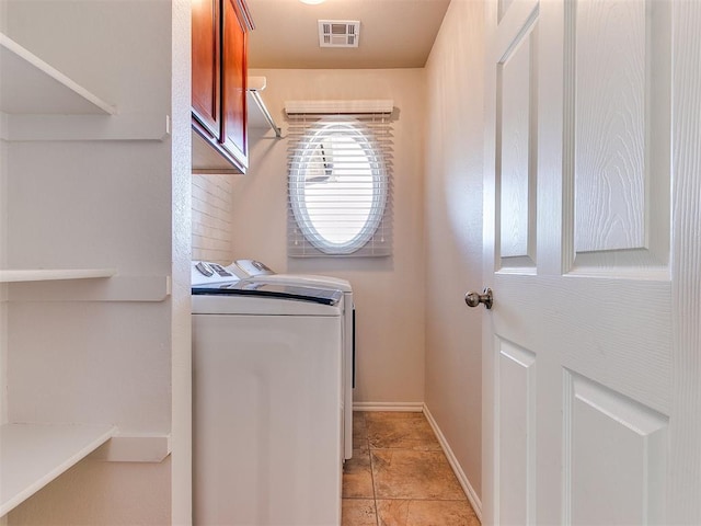 washroom featuring visible vents, cabinet space, washer and clothes dryer, and baseboards