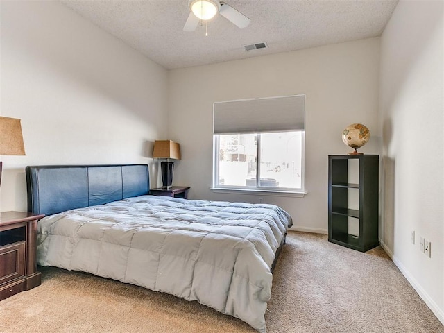 bedroom with carpet floors, visible vents, a ceiling fan, a textured ceiling, and baseboards