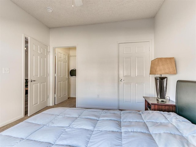 bedroom with a textured ceiling, baseboards, and carpet flooring