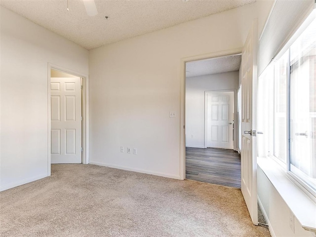 spare room featuring a ceiling fan, carpet, a textured ceiling, and baseboards