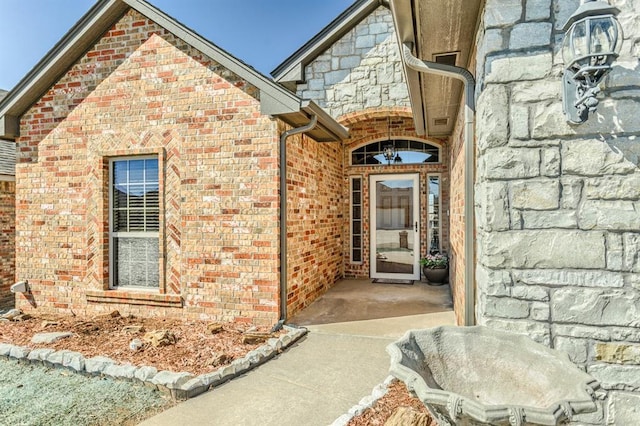 entrance to property featuring brick siding