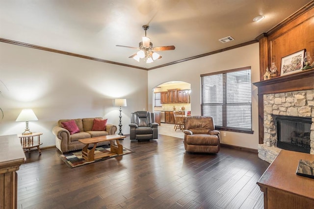 living room featuring arched walkways, wood finished floors, visible vents, and baseboards