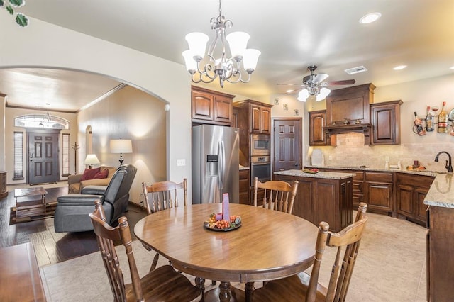 dining space featuring recessed lighting, visible vents, arched walkways, and ceiling fan with notable chandelier