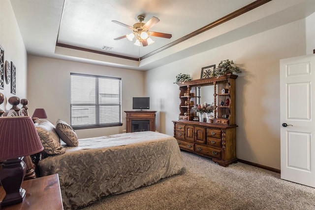 carpeted bedroom featuring a tray ceiling, visible vents, crown molding, and baseboards