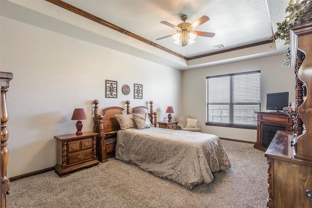 bedroom with carpet flooring, visible vents, baseboards, a raised ceiling, and crown molding