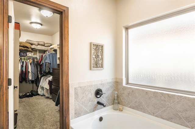 bathroom featuring a spacious closet and a bath