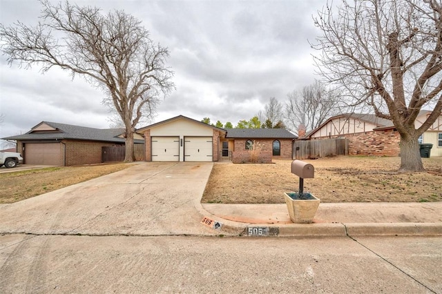 single story home with a garage, concrete driveway, brick siding, and fence