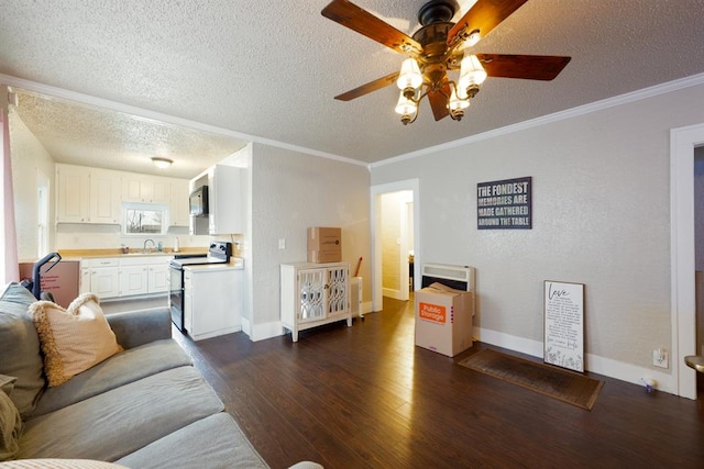 living room with dark wood-style floors, a textured ceiling, baseboards, and crown molding