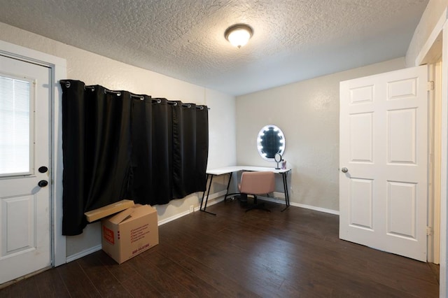 home office featuring a textured ceiling, a textured wall, wood finished floors, and baseboards