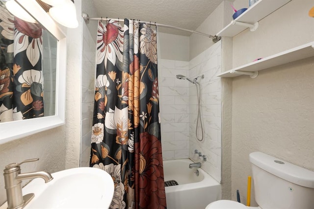 bathroom featuring shower / bath combination with curtain, a textured wall, toilet, a sink, and a textured ceiling