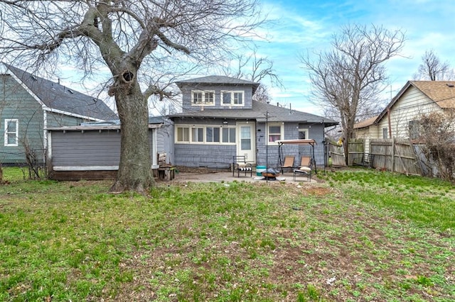 back of house with a fenced backyard, a lawn, a fire pit, and a patio